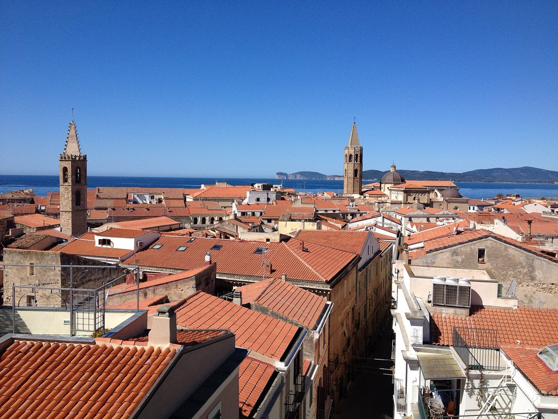 Alghero z moře — hradby a staré město na útesu